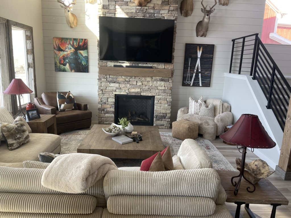 Cozy TV lounge area with built in fireplace comfortable seating and modern decor in a remodeled home by BBA Construction in Park City Utah