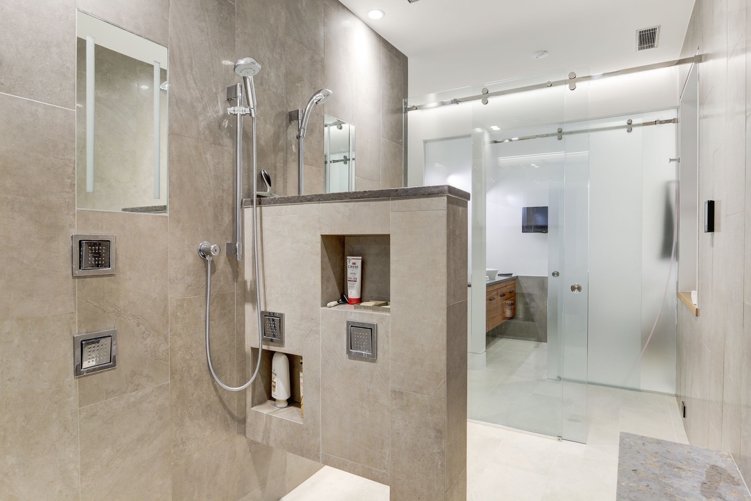Beautiful modern bathroom with tiled walls glass shower and sleek fixtures remodeled by BBA Construction in Park City Utah