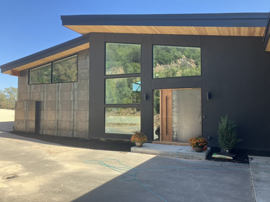 Newly completed modern house exterior with clean lines large windows and fresh landscaping built by BBA Construction in Utah